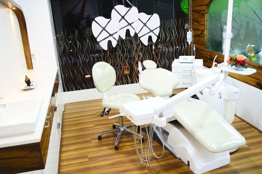 Treatment room at Tooth Works with a white dental chair and tooth-shaped pendant lights